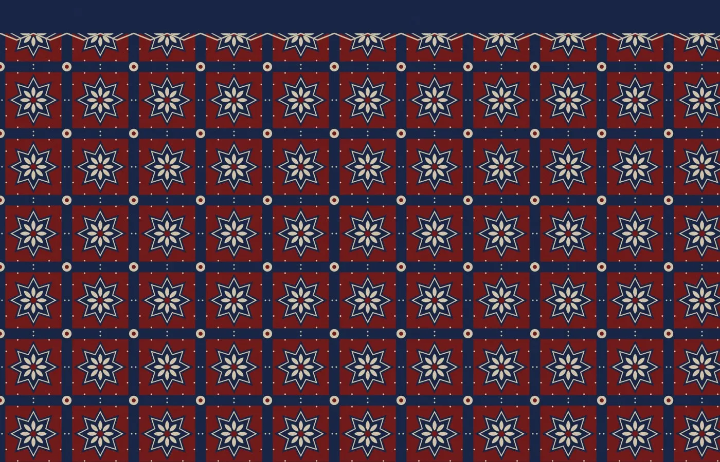 A tight repeating ajrakh-style pattern: indigo grid lines framing madder-red squares, each holding a cream eight-pointed star and a small flower.